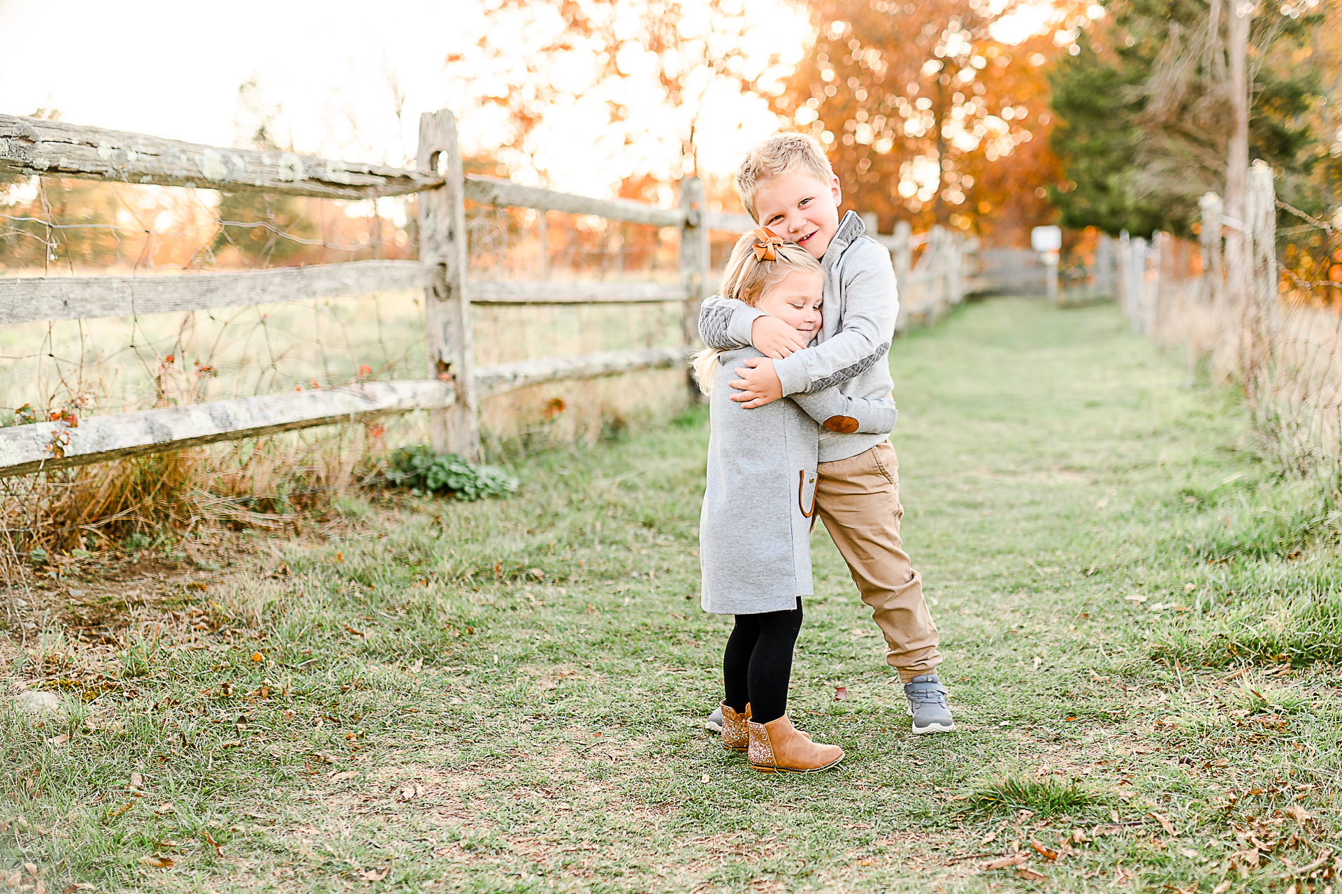 Photo by Norwell Photographer Christina Runnals | Little boy hugging his little sister in front of a fence