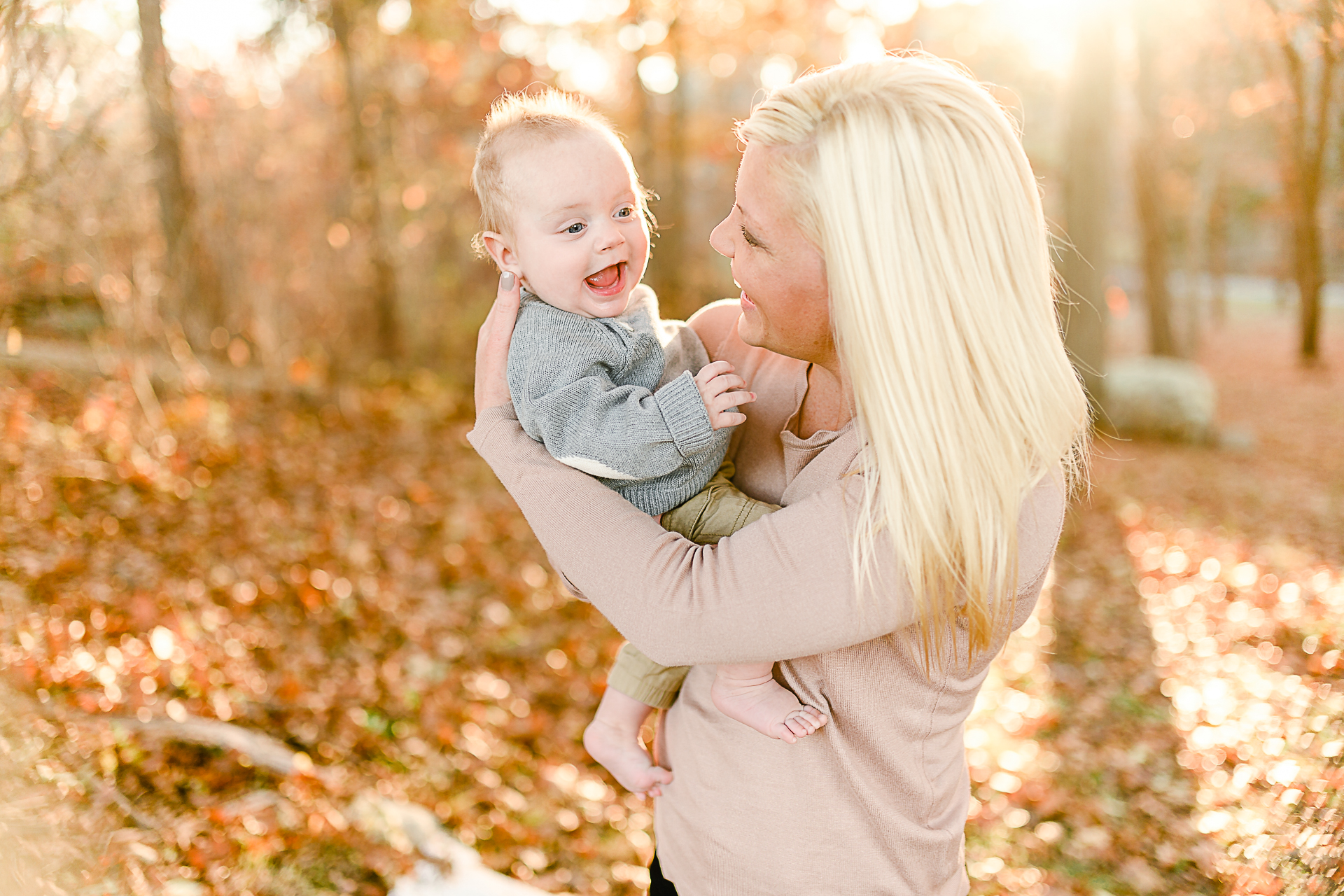 Photo by Norwell Photographer Christina Runnals | Mom and baby dancing around surrounded by sunlight and golden leaves