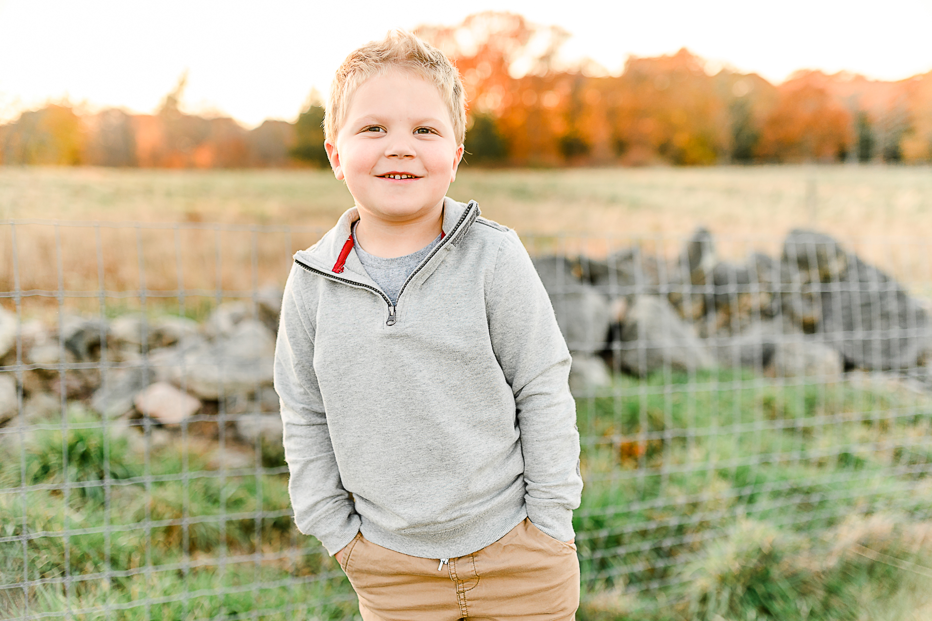 Photo by Norwell Photographer Christina Runnals | Little boy in a field smiling for a photo