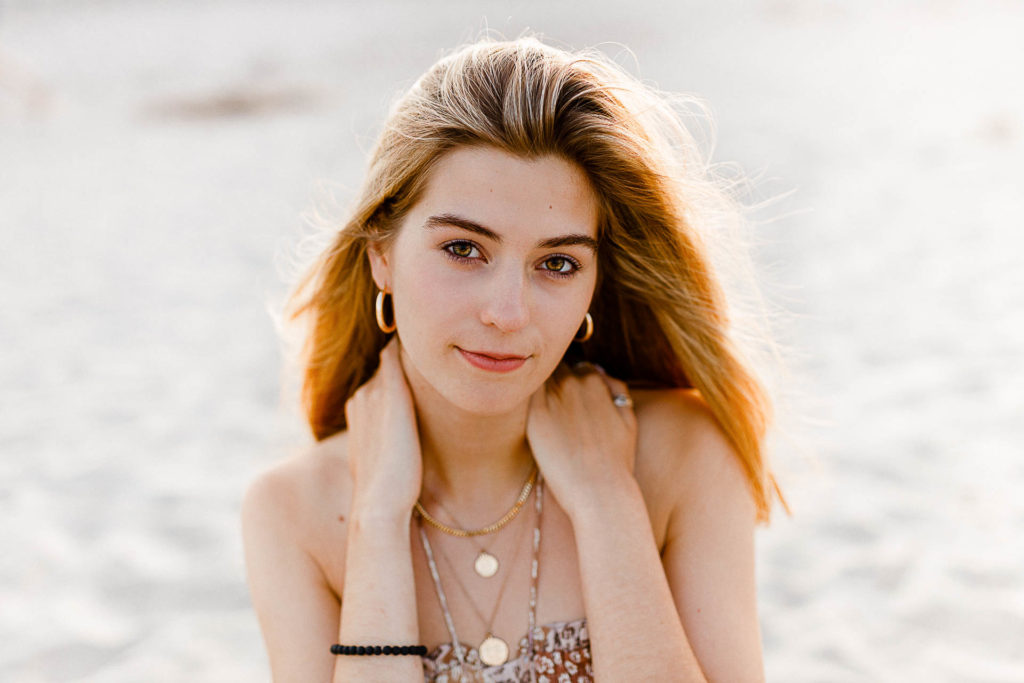 Photo by Cohasset senior portrait photographer Christina Runnals | High school senior girl sitting on the beach at sunset