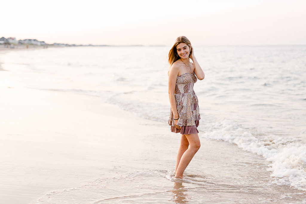 Photo by Cohasset senior portrait photographer Christina Runnals | High school senior girl standing on the shoreline of the ocean