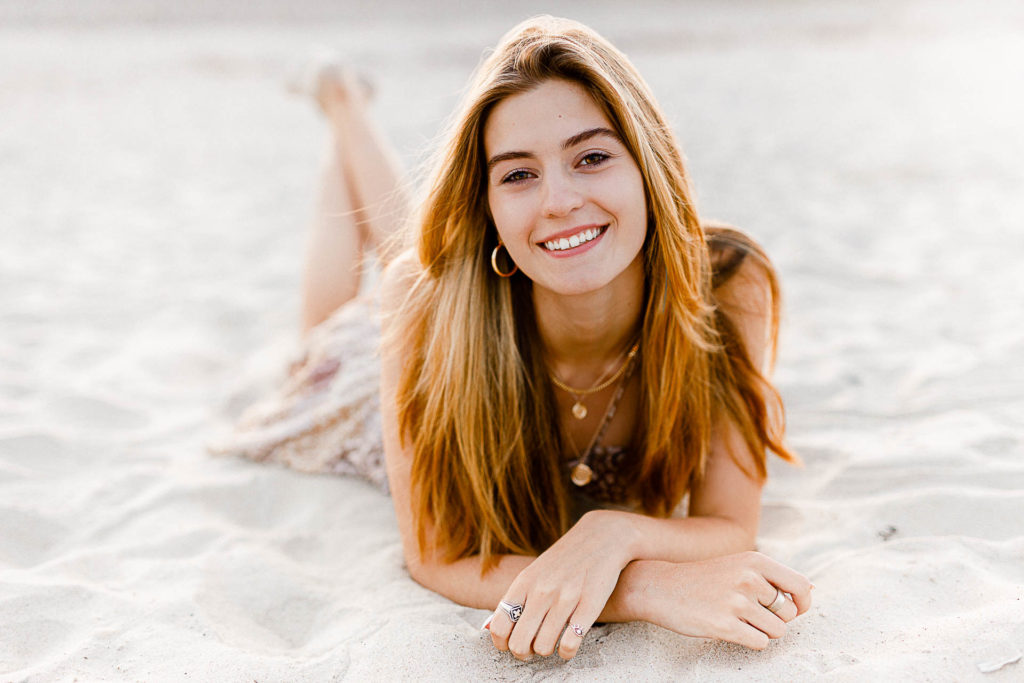Photo by Cohasset senior portrait photographer Christina Runnals | High school senior girl laying on the beach smiling