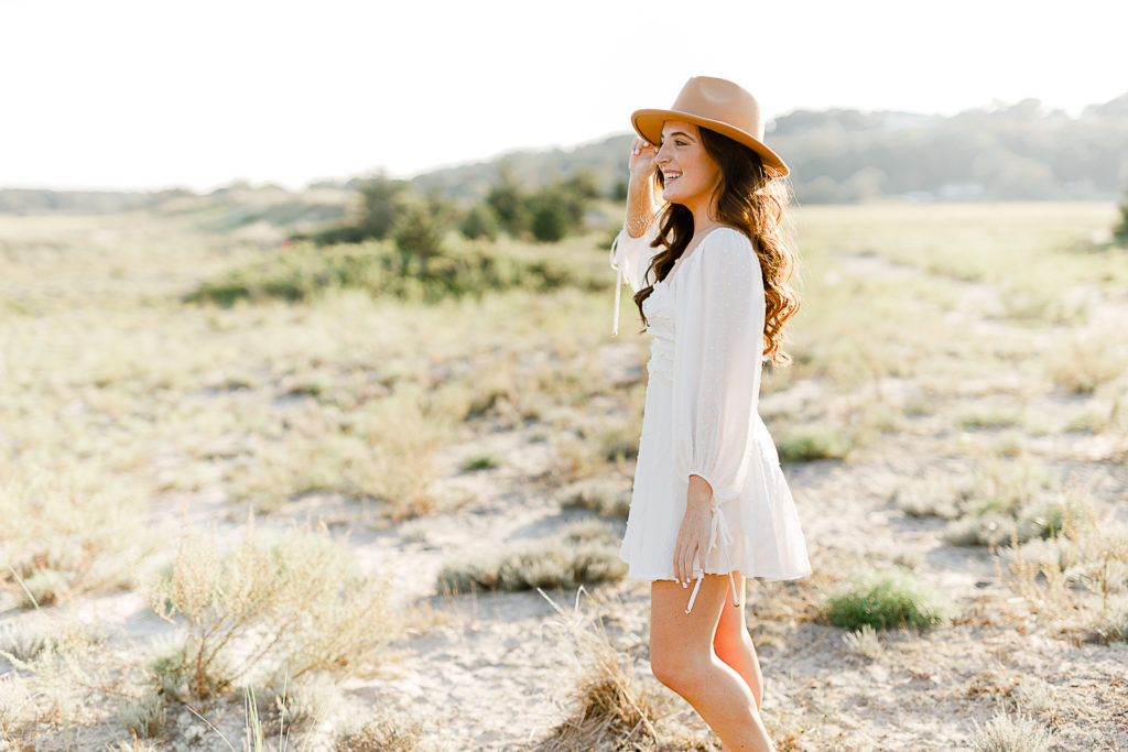 Beach picture by senior photographer Christina Runnals | | High school senior girl standing in a field wearing a white dress