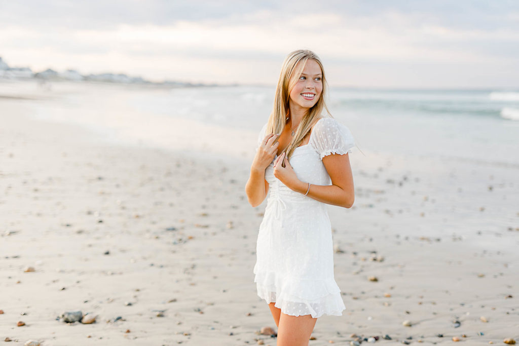 Photo by Massachusetts senior portrait photographer Christina Runnals | High school aged girl standing on the beach smiling for her senior portrait pictures