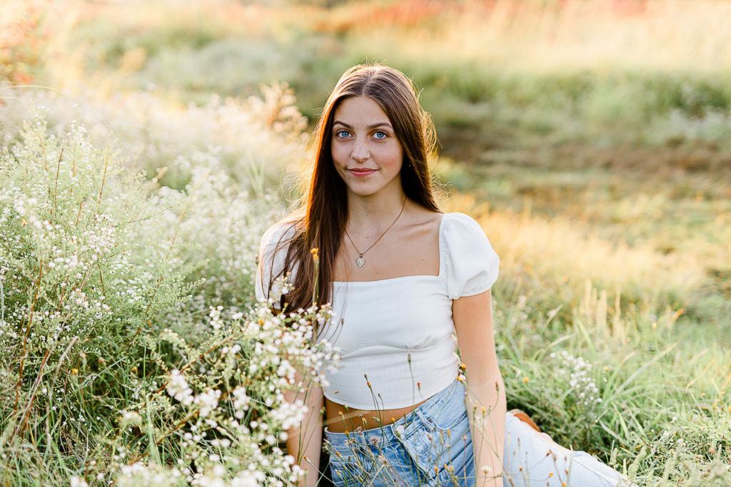 Photo by Boston Senior Photographer Christina Runnals | High school senior girl sitting in a wildflower field 