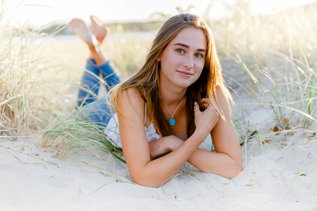 Cohasset Sandy Beach Senior Pictures by Cohasset senior portrait photographer Christina Runnals | A high school senior girl laying on the sand at Cohasset Sandy Beach