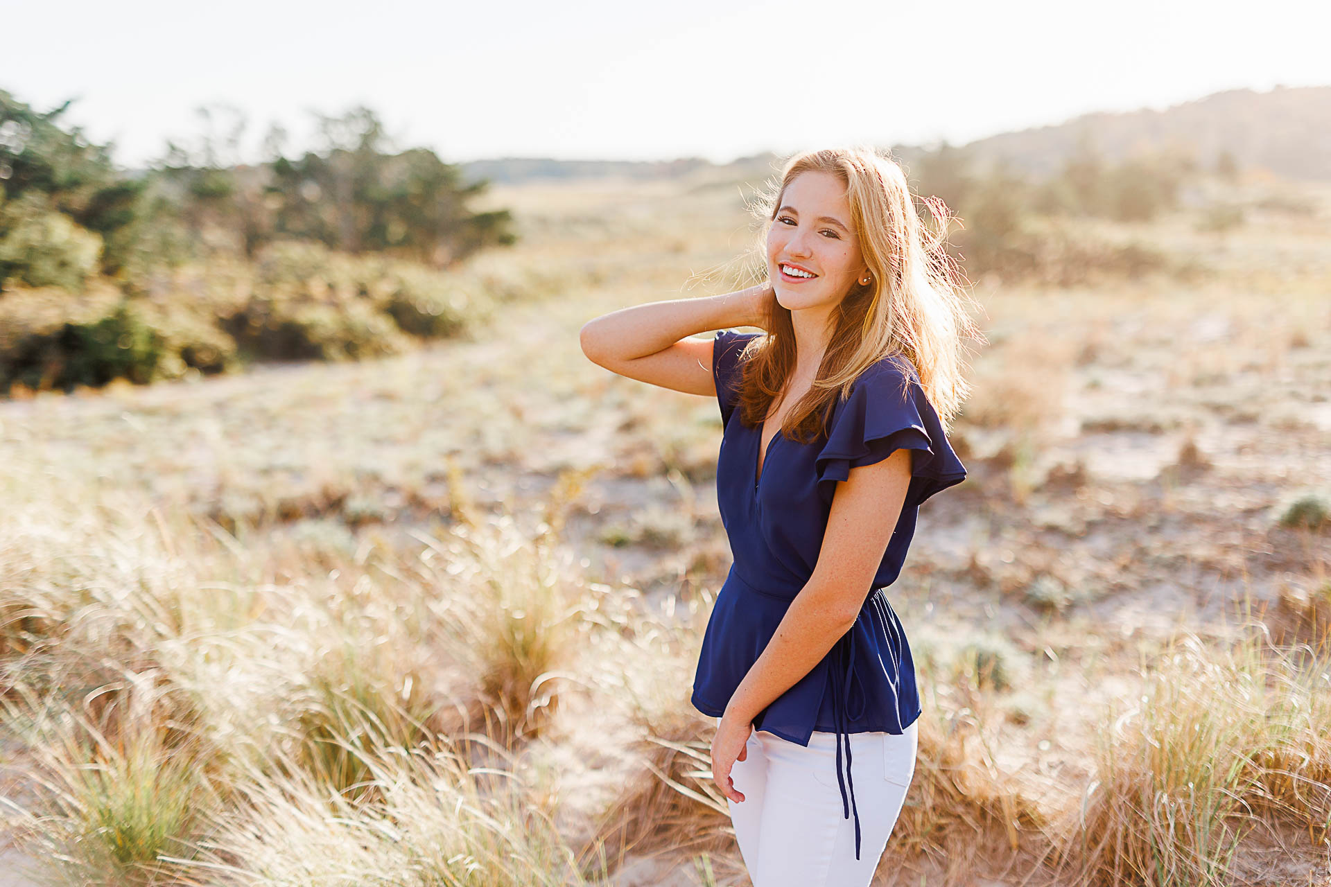 Photo by Cohasset senior photographer Christina Runnals | High school senior girl standing in beach grass and laughing
