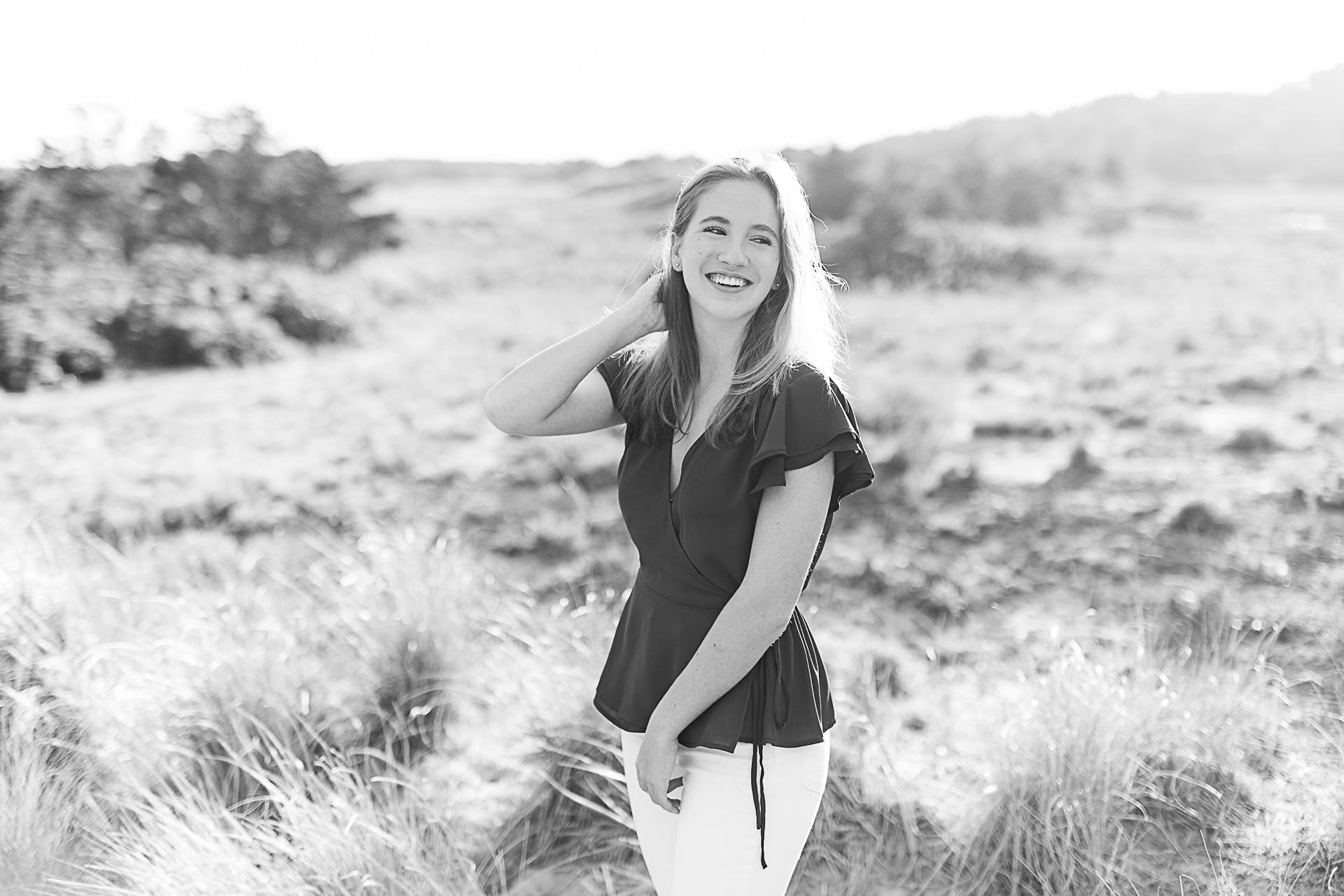 Photo by Cohasset senior photographer Christina Runnals | High school senior girl standing in beach grass and laughing