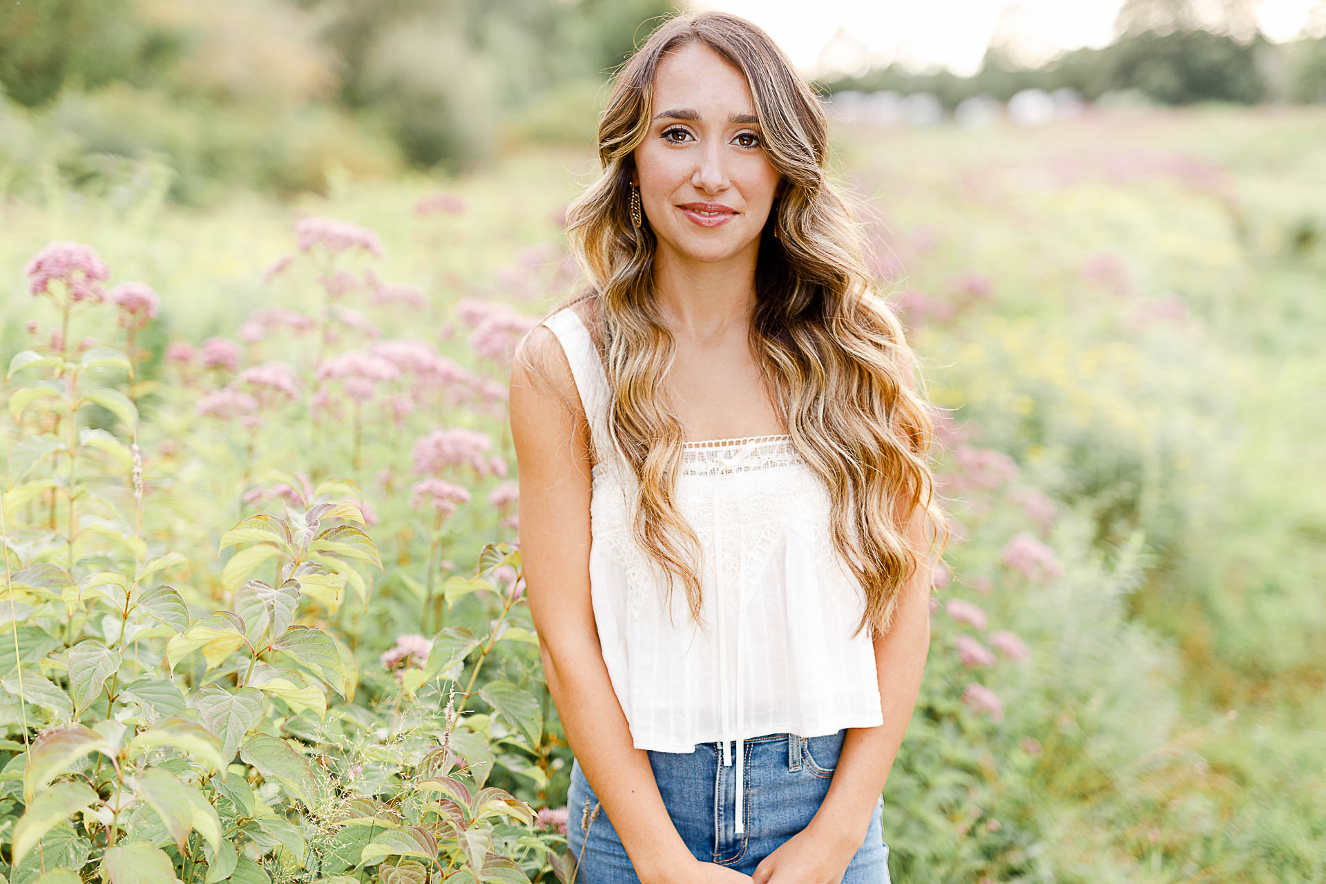 Photo by Kingston Senior Photographer | High school senior girl standing in a wildflower field with purple flowers