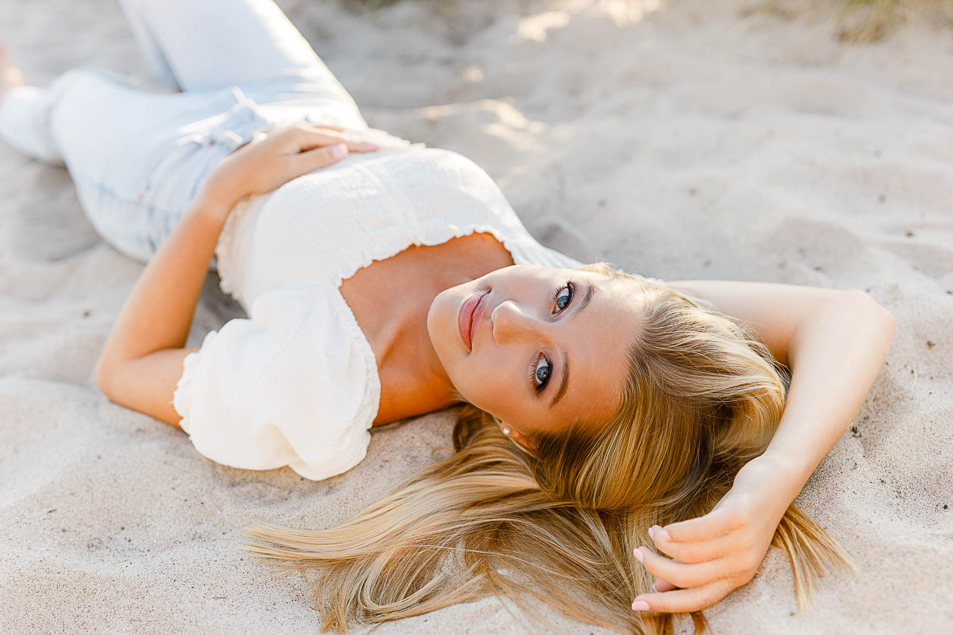 Photo by Scituate Senior Photographer Christina Runnals | High school senior girl laying in the sand at a Scituate beach