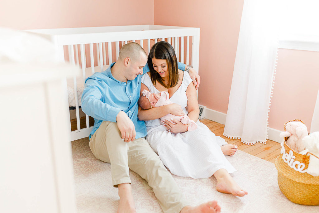 Parents with newborn in pink nursery