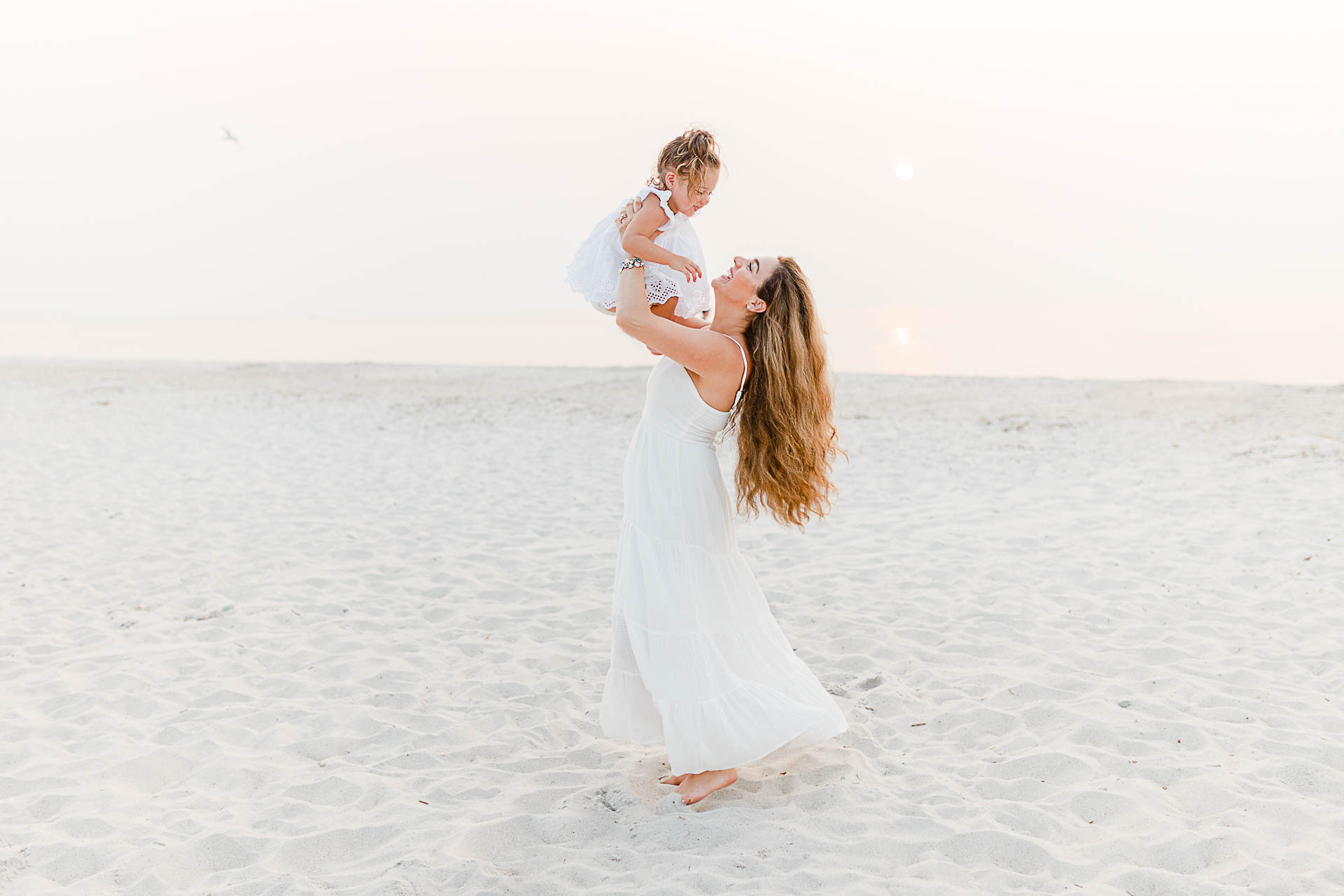 Photo by Cape Cod Family Photographer Christina Runnals | Mom spinning daughter on beach