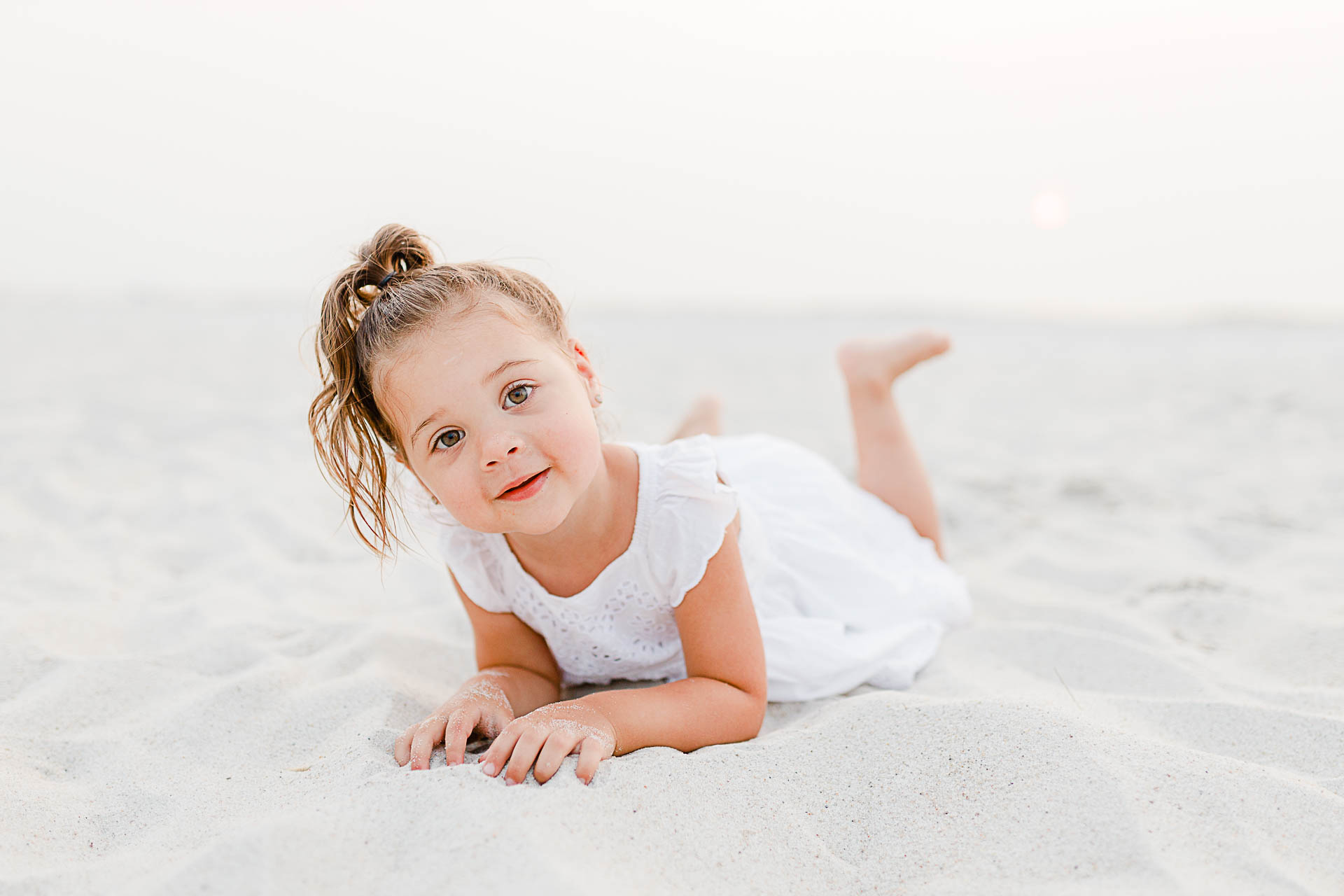 Photo by Cape Cod Family Photographer Christina Runnals | Little girl laying on beach