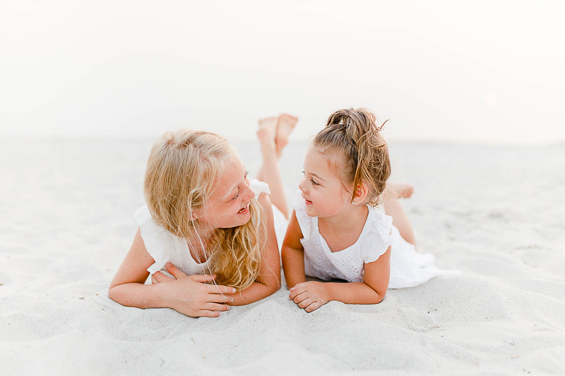 Photo by Cape Cod Family Photographer Christina Runnals | Two little girls laying on beach