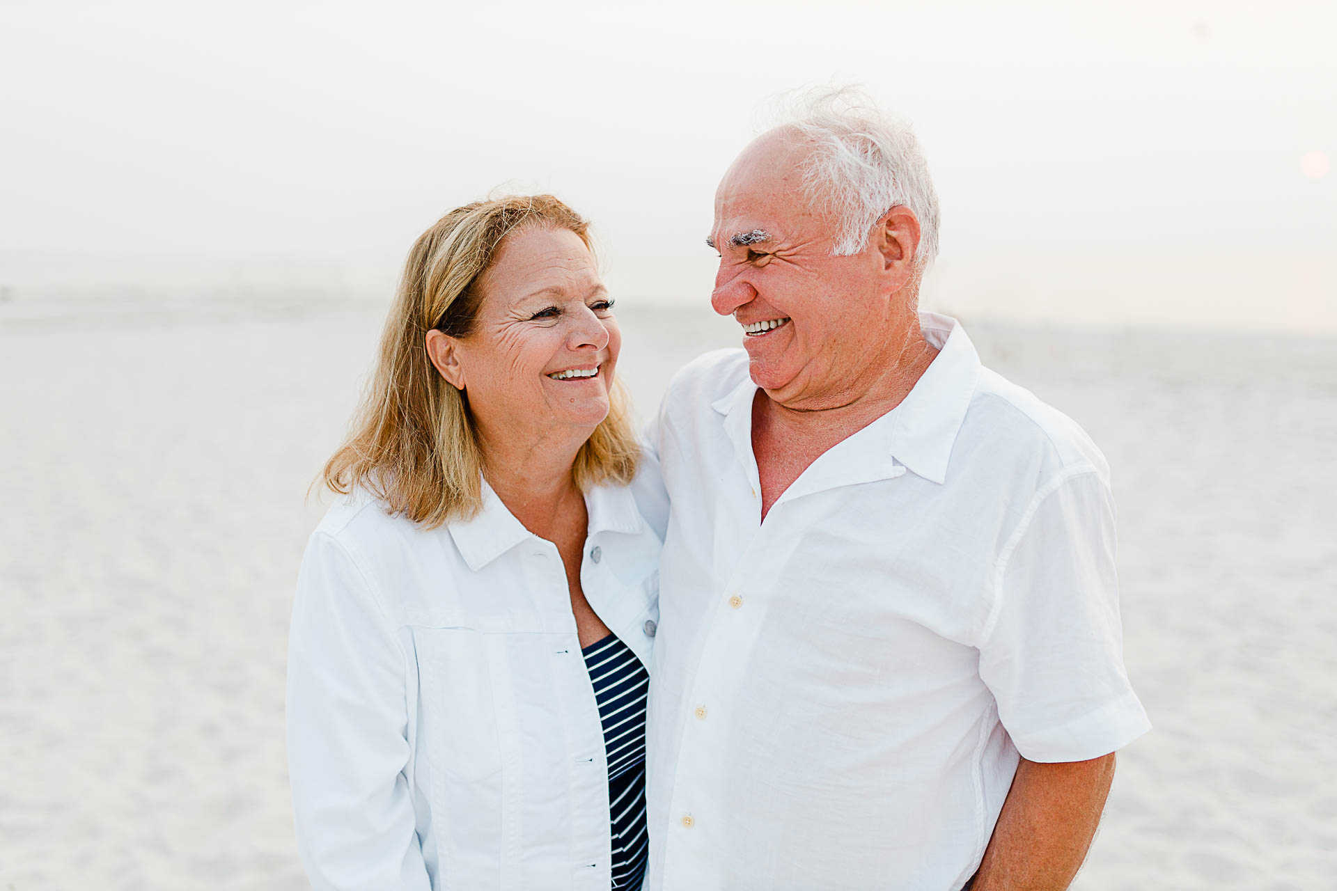 Photo by Cape Cod Family Photographer Christina Runnals | Grandparents looking at each other adoringly on beach