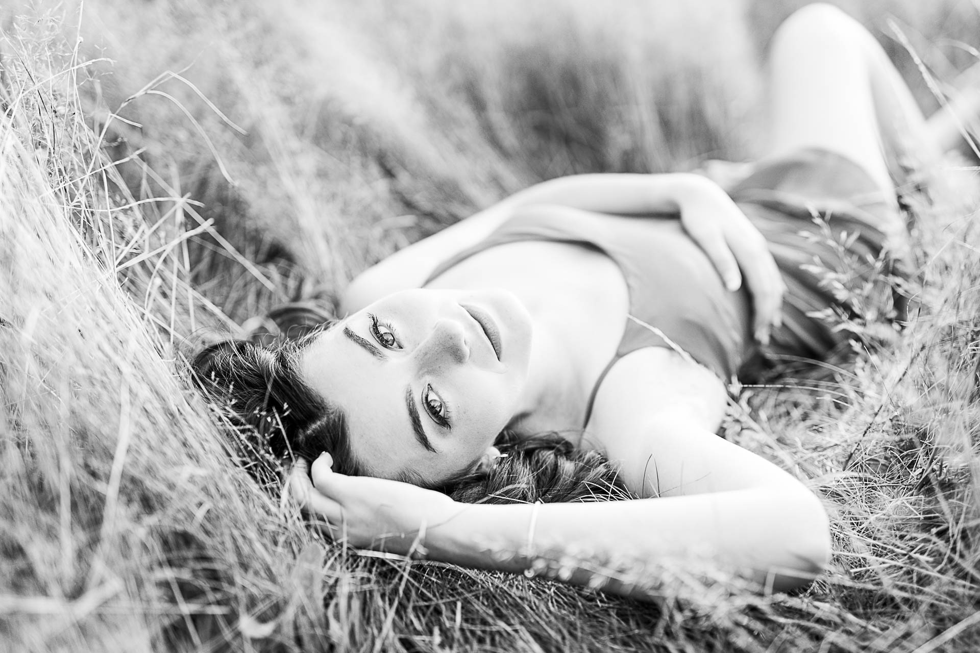 Photo by Duxbury senior portrait photographer Christina Runnals | High school senior girl wearing a dress and laying in a field | Hot senior pictures