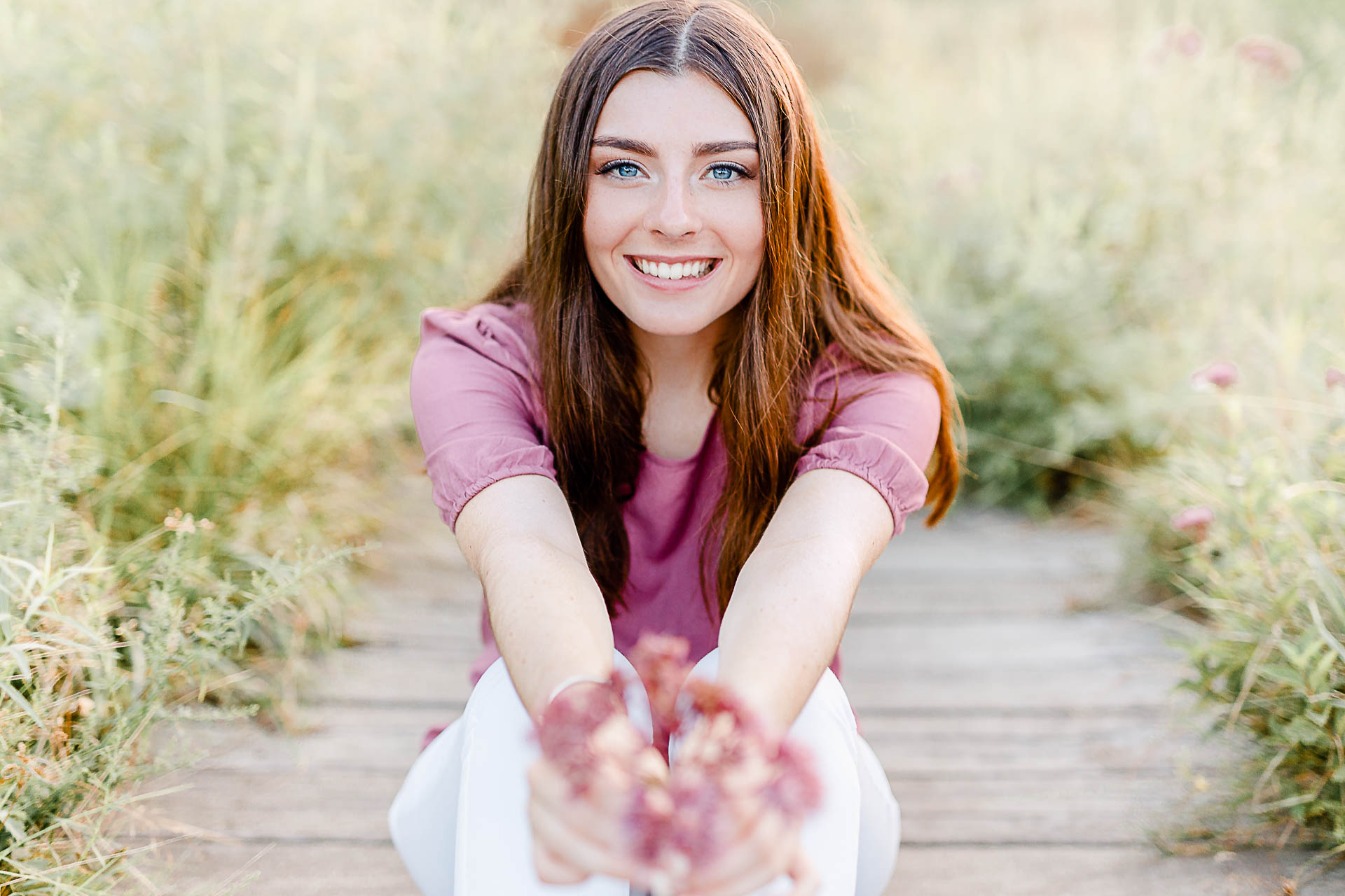 Photo by Duxbury senior portrait photographer Christina Runnals | High school senior girl holding flowers sitting on a little bridge