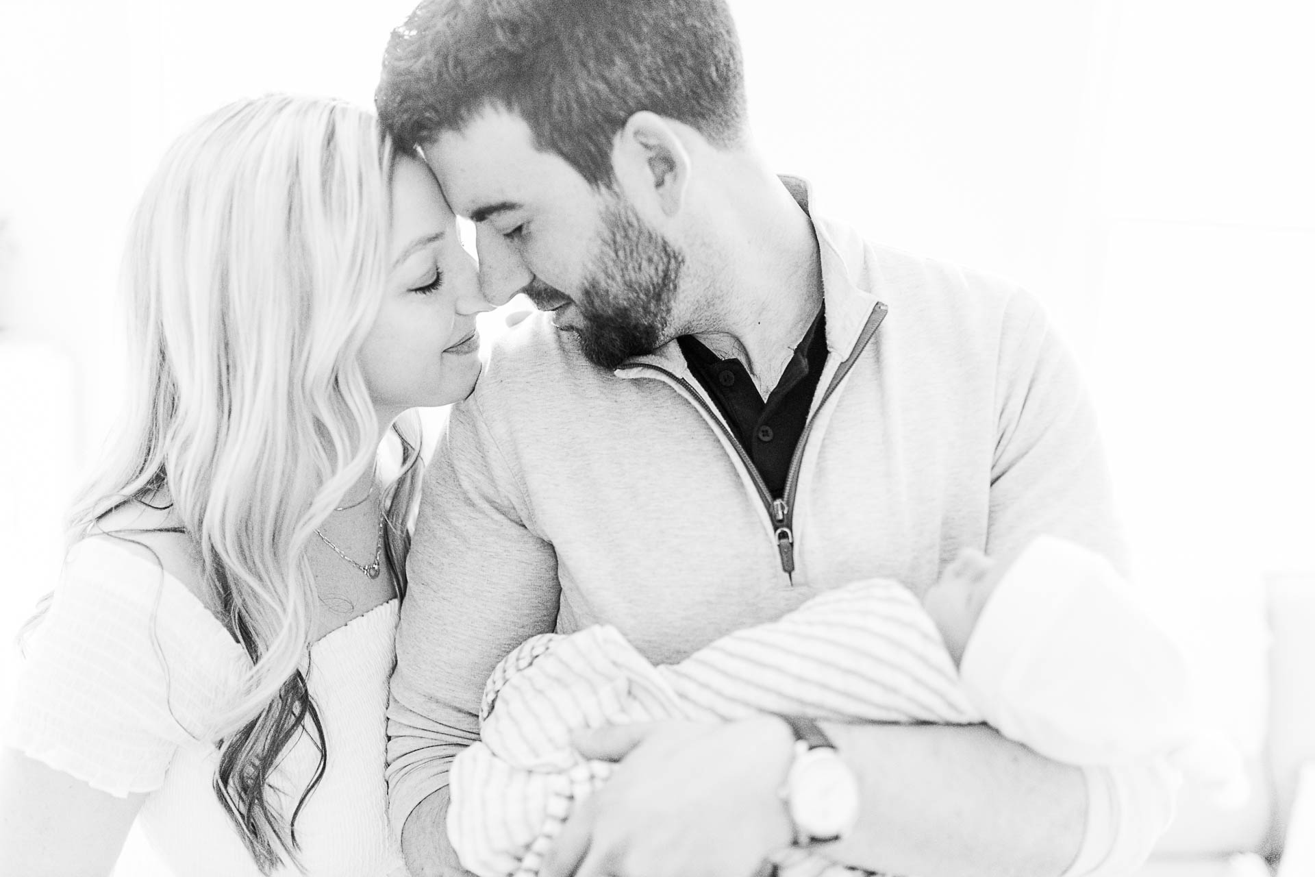 Photo by Boston Newborn Photographer Christina Runnals | Couple touching noses and holding their newborn baby boy