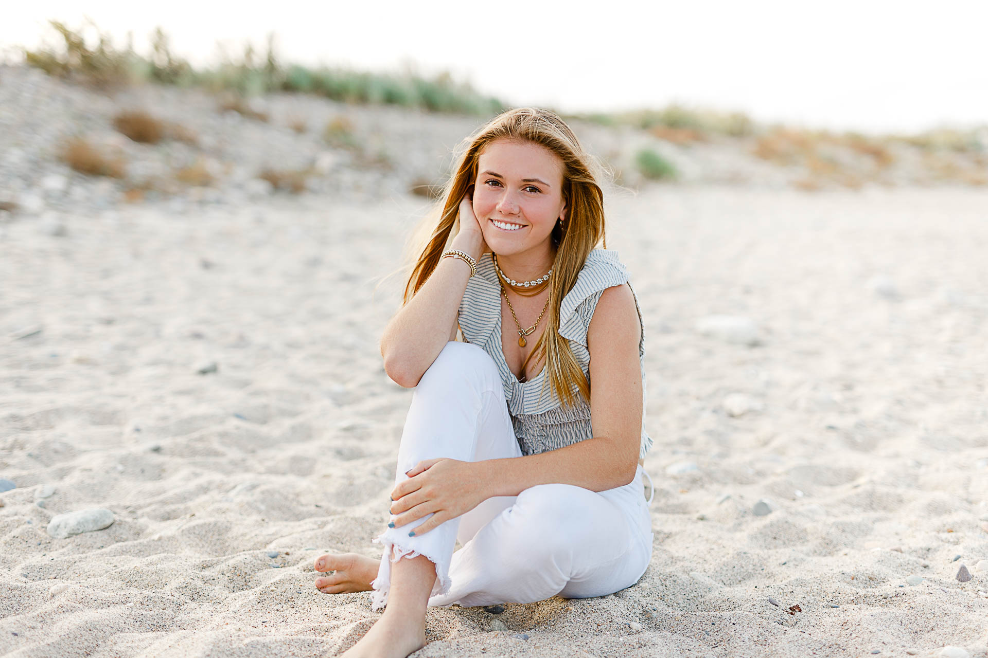 Photo by Scituate Senior Portrait Photographer Christina Runnals | High school senior girl sitting in the sand with dunes in the background