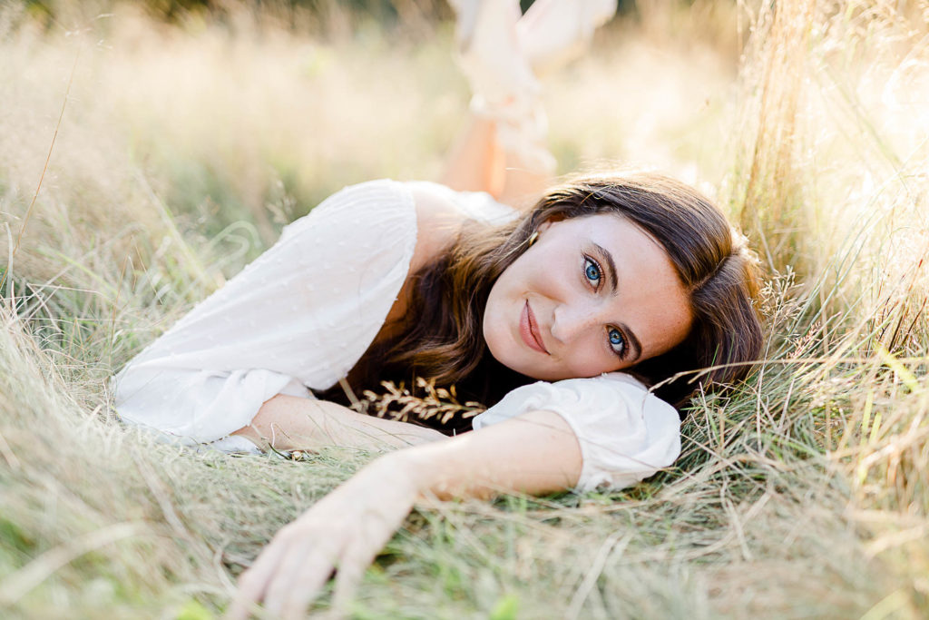 Photo by Scituate Senior Portrait Photographer Christina Runnals | High school senior girl laying in the grasses for her senior portraits