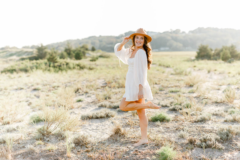 Photo by Scituate Senior Portrait Photographer Christina Runnals | High school senior girl standing in beach grass wearing a hat