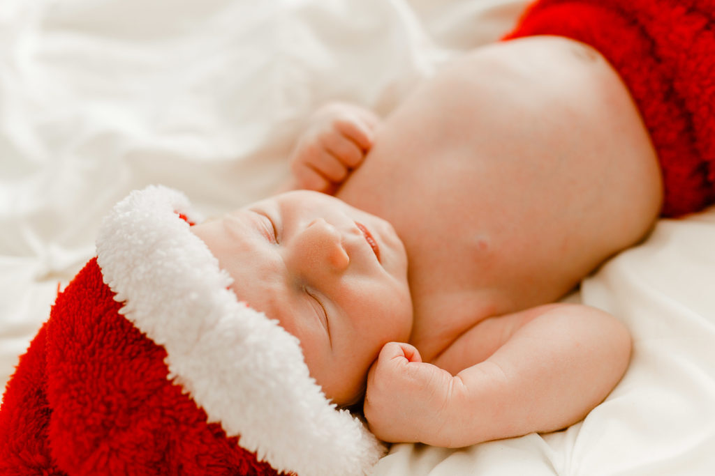 Lifestyle newborn picture with Scituate Massachusetts baby photographer | baby in a santa outfit