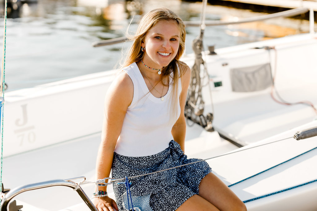 Cohasset Yacht Club Senior Pictures with Christina Runnals Photography | Girl sitting on sailboat