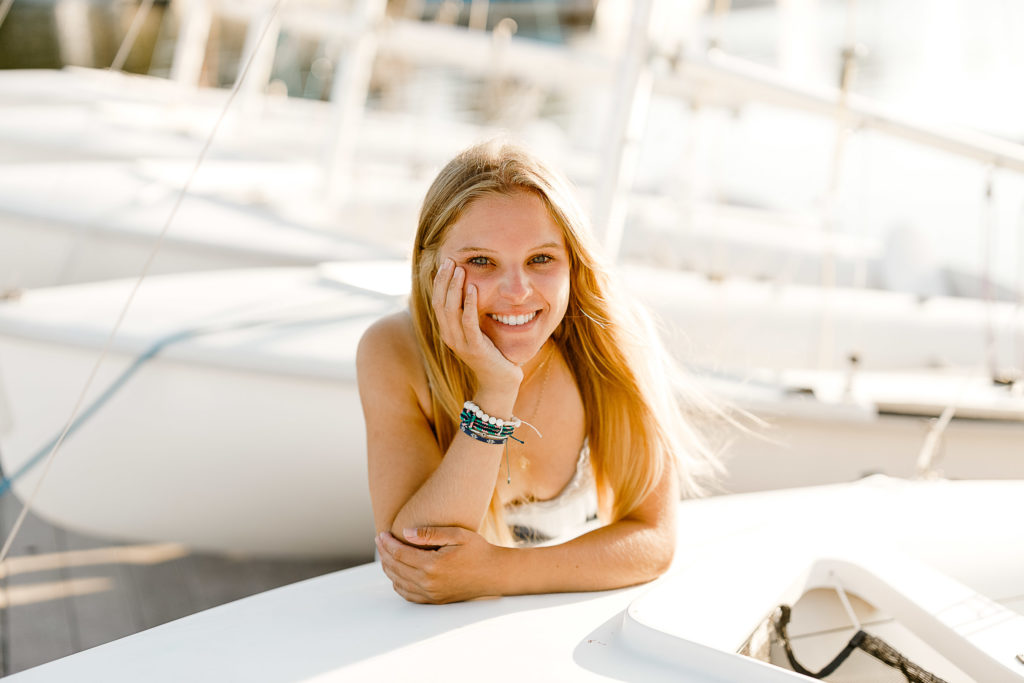 Gabrielle Henry's Cohasset Yacht Club Senior Pictures with Christina Runnals Photography | girl leaning on sailboat
