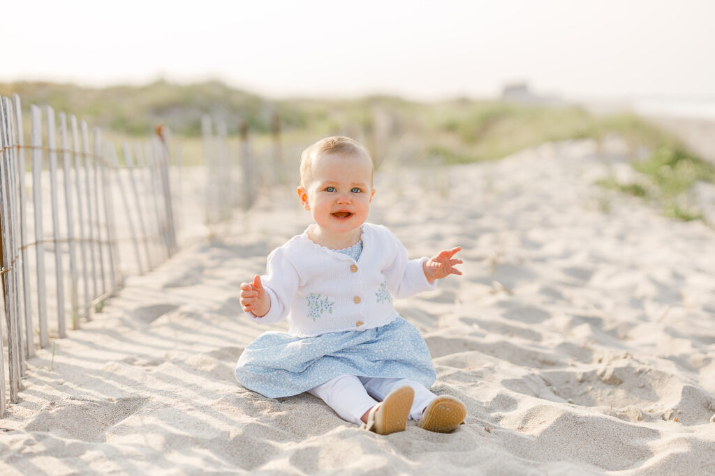 Baby on the beach by a fence, taken by Scituate Massachusetts photographer Christina Runnals