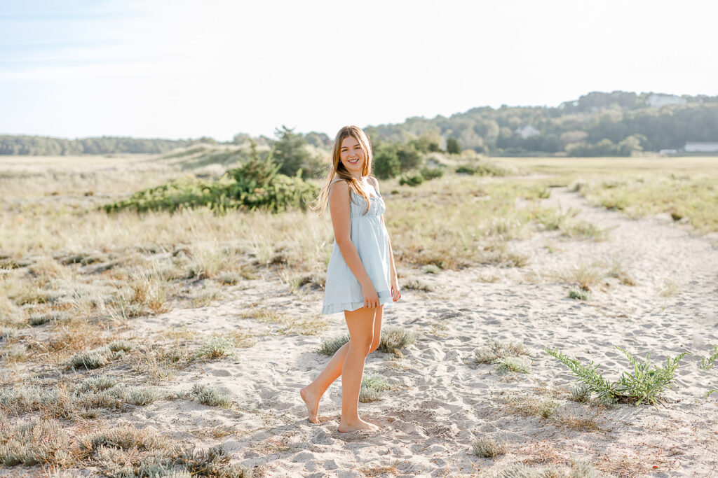 Izzy Monteiro senior pictures by top New England senior photographer Christina Runnals | senior photos taken on the beach in Massachusetts of girl with long blond hair wearing a light blue dress