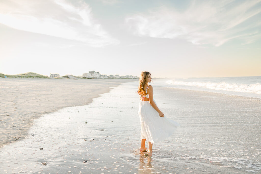 Senior pictures at sunrise are stunning in New England | Image by Christina Runnals Photography | Girl twirling on a beach at sunrise