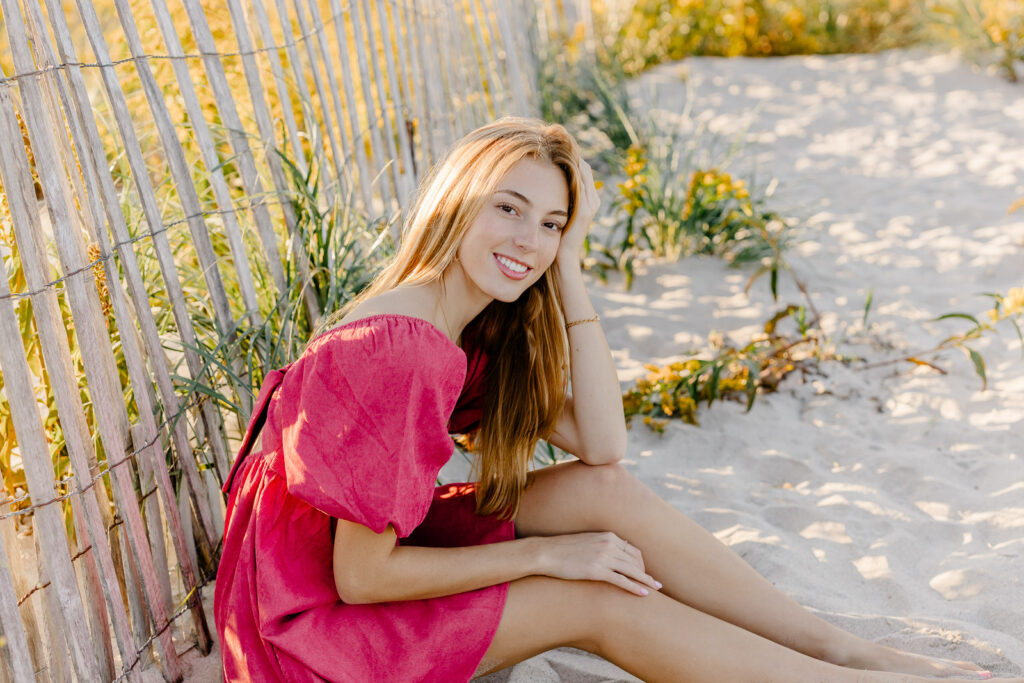 Stella's Boston Latin senior portraits by Christina Runnals Photography taken at the beach | Yellow flowers | Pink dress senior pictures |
 Cute senior girl pose