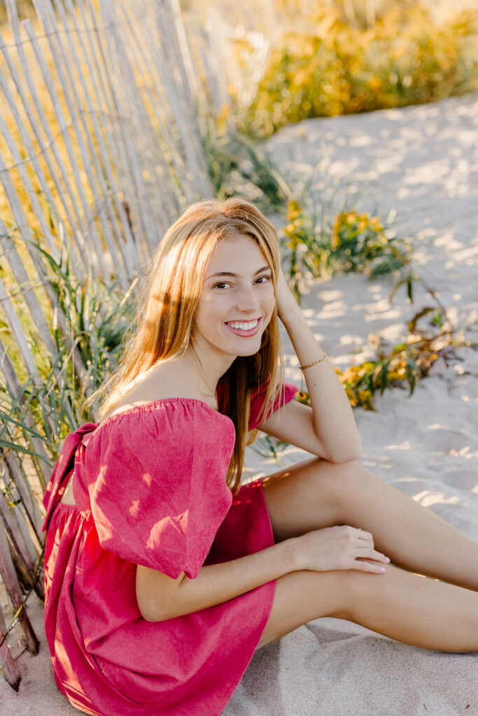 Stella's Boston Latin senior portraits by Christina Runnals Photography taken at the beach | Yellow flowers | Pink dress senior pictures |
 Cute senior girl pose