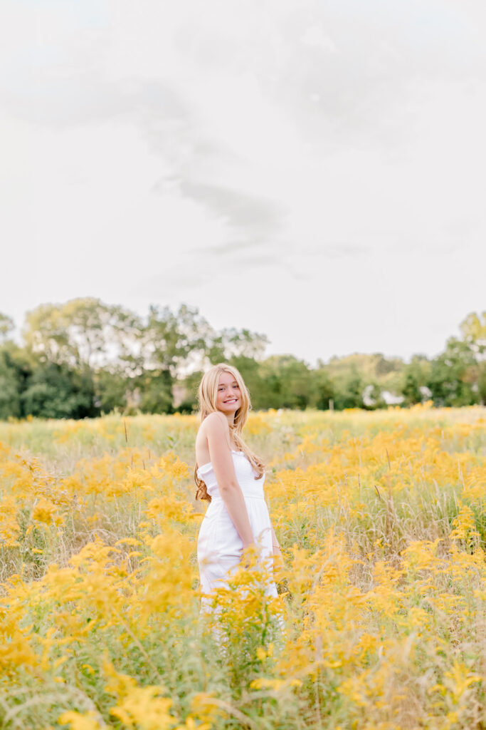 Massachusetts senior photos with yellow wildflowers and a girl wearing a long white dress